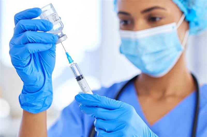 Nurse preparing an injectable anabolic steroid dose under professional medical supervision.