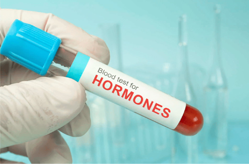 Hand holding a hormone blood test tube for low testosterone testing price comparison.