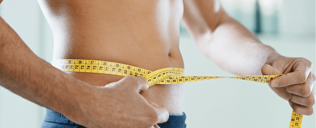 A patient measuring his waist size after weight loss treatment in Bangkok