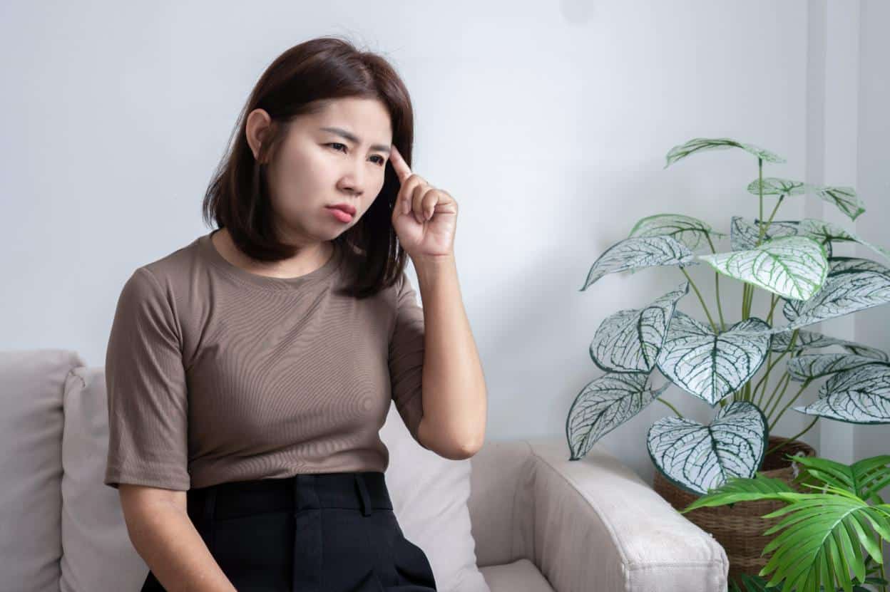 An Asian woman with impaired concentration, a main symptom of brain fog