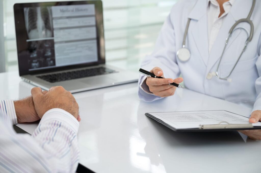 doctor discussing a list of diseases treated by stem cells with a patient during consultation.