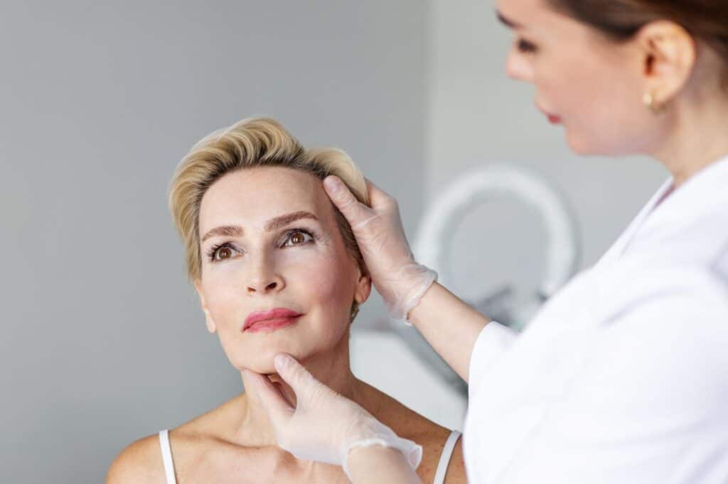 Doctor examining a patient's skin to assess what causes aging over time