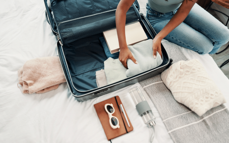 Traveler packing a suitcase for a trip to Thailand with a weight loss pen on the bed