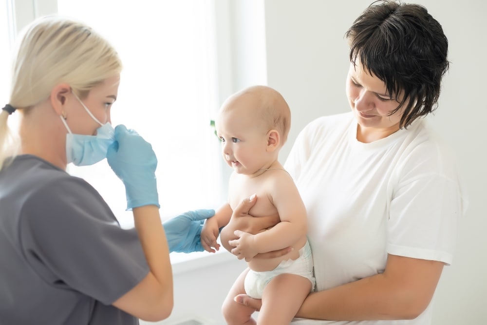 A nurse administering the meningococcal B vaccine to a baby.