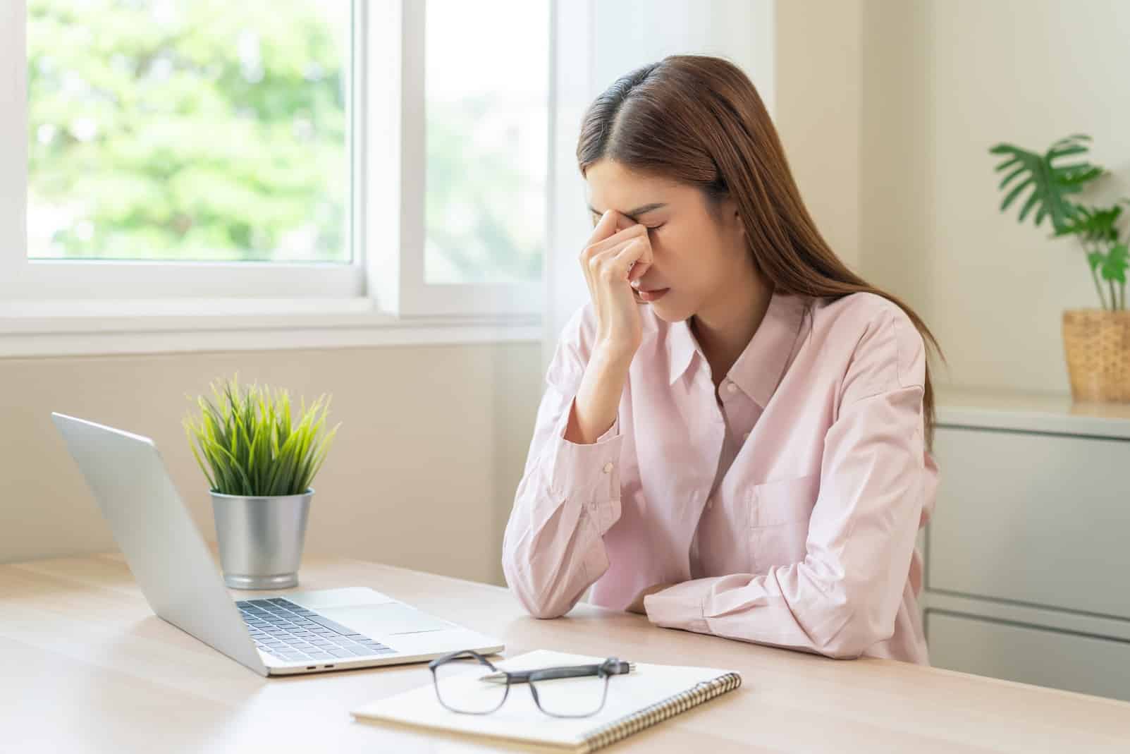 A woman looking stressed and tired. Persistent low mood is at the core of depression symptoms