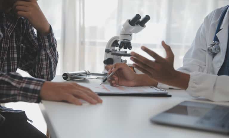 Doctor discussing a medical report with an adult male patient during a hormone evaluation.