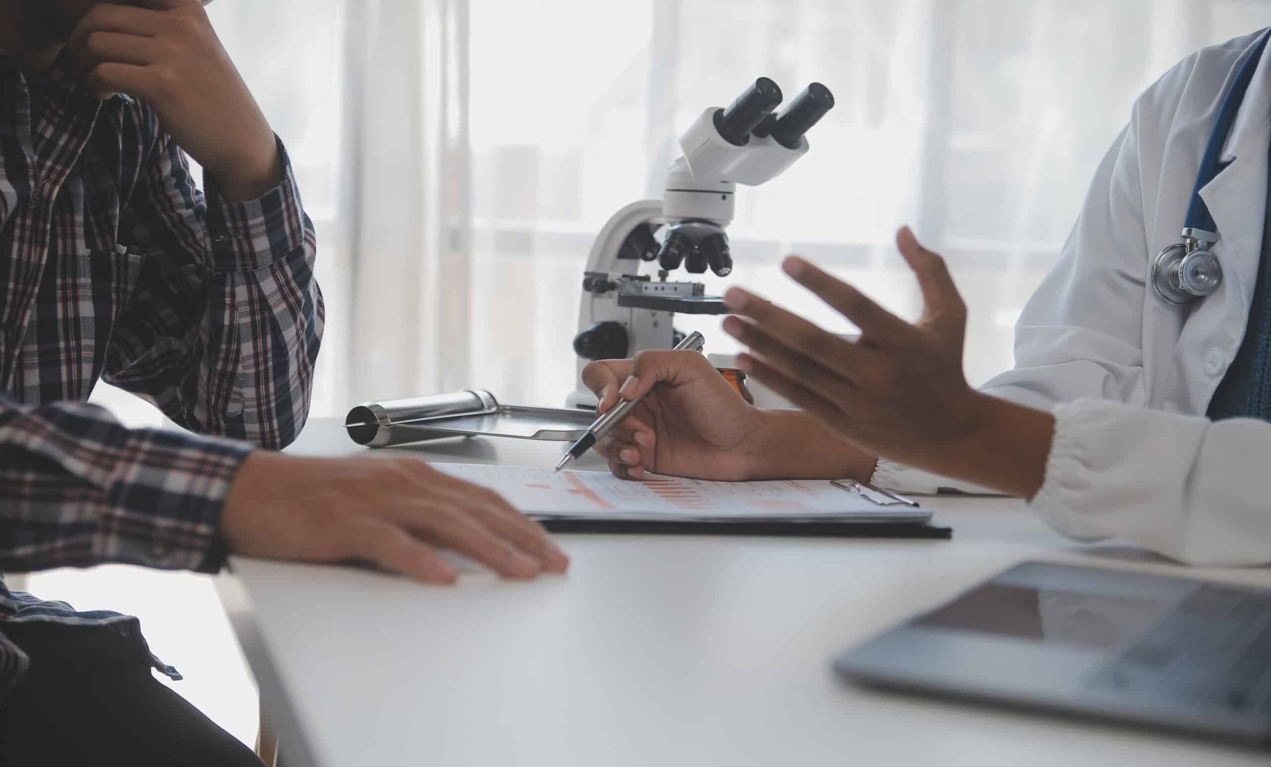 Doctor discussing a medical report with an adult male patient during a hormone evaluation.