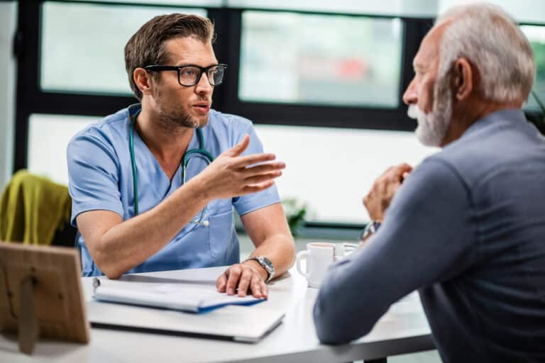 A doctor discusses tadalafil treatment with an older man during a medical consultation.